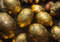 Composition of coloured and golden eggs, with artistic decorations, with depth of field, photographic lighting and close-ups.
