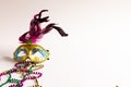 Composition of colourful mardi gras beads and carnival mask on white background with copy space Royalty Free Stock Photo