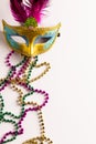 Composition of colourful mardi gras beads and carnival mask on white background with copy space Royalty Free Stock Photo