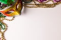 Composition of colourful mardi gras beads and carnival mask on white background with copy space Royalty Free Stock Photo