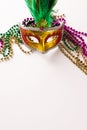 Composition of colourful mardi gras beads and carnival mask on white background with copy space Royalty Free Stock Photo