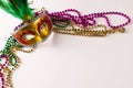 Composition of colourful mardi gras beads and carnival mask on white background with copy space Royalty Free Stock Photo