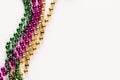 Composition of colourful mardi gras beads on white background with copy space Royalty Free Stock Photo