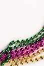 Composition of colourful mardi gras beads on white background with copy space Royalty Free Stock Photo