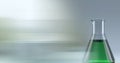 Composition of conical flask of green liquid, with blurred copy space