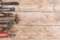 Composition of construction tools on an old battered wooden surface of tools: pliers, pipe wrench, screwdriver, hammer, metal shea