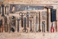 Composition of construction tools on an old battered wooden surface of tools: pliers, pipe wrench, screwdriver, hammer, metal shea Royalty Free Stock Photo