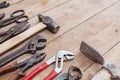 Composition of construction tools on an old battered wooden surface of tools: pliers, pipe wrench, screwdriver, hammer, metal shea Royalty Free Stock Photo