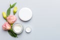 Composition with cosmetic products and beautiful roses on color background. Copy space, flat lay