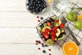 Composition cup of fresh fruit salad on white wooden table, top view Royalty Free Stock Photo