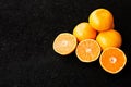 A composition of cut in halves oranges and tangerines on a black background Royalty Free Stock Photo