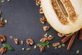 Composition of cut melon, walnuts and cinnamon. Sweet fruits and crunchy nuts on a table background. Vegetarian food Royalty Free Stock Photo