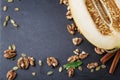 Composition of cut melon, walnuts and cinnamon. Sweet fruits and crunchy nuts on a table background. Vegetarian food Royalty Free Stock Photo