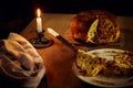 Composition with cut panettone the italian specialty Christmas cake with raisins and berries on a wooden table with burning