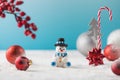 Snowman in hat and red baubles with traditional Christmas ornate on fake snow Royalty Free Stock Photo
