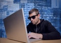 Composition of data processing and binary coding over hacker wearing sunglasses using laptop Royalty Free Stock Photo