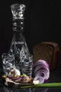 Composition with a decanter of vodka with chopped onions, garlic, bread, a herring sandwich and black bread Royalty Free Stock Photo