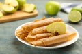 Composition with delicious fruit leather rolls and apple on blue wooden table