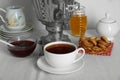 Composition with delicious ring shaped Sushki (dry bagels) and tea on white tablecloth near wall