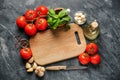 Composition with delicious tomatoes, wooden board and products on grey background