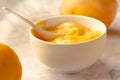 Composition with delicious Yellow lemons and Lemon curd in a sausepan white bowl on marble background Royalty Free Stock Photo