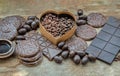 Composition of different Dark chocolate bars and pieces, Melted chocolate and Coffee beans on old wooden background