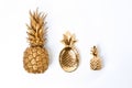 Composition with different gold pineapples on white background