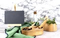 Composition with different spices on wooden double cellar and mortar with rosemary and green napkin, board for copy space, on