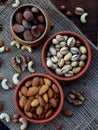 A composition from different varieties of nuts on a wooden background - almonds, cashews, peanuts, walnuts, hazelnuts, pistachios. Royalty Free Stock Photo