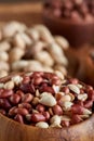 A composition from different varieties of nuts in a wooden bowl over wooden background, close-up, shallow depth of field Royalty Free Stock Photo