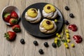 Composition of dish with typical Italian dessert called zeppole, strawberries, blueberries, heart-shaped chocolates and mimosa Royalty Free Stock Photo