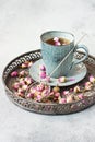 Rose buds tea, tea cup, strainer  with rosebuds on  vintage tray Royalty Free Stock Photo