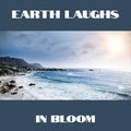 Composition of earth laughs in bloom text over seaside