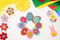 Composition of Easter eggs, wreath, flowers, sun, chicken, rabbit from multi-colored paper, step by step. Child makes crafts his