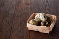 Composition of eggs quail box, eggs on a homespun napkin, boxwood on wooden background, top view Royalty Free Stock Photo