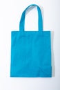 Composition of empty blue canvas shopping bag lying flat on white background Royalty Free Stock Photo