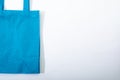 Composition of empty blue canvas shopping bag lying flat on white background Royalty Free Stock Photo