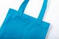 Composition of empty blue canvas shopping bag lying flat on white background Royalty Free Stock Photo