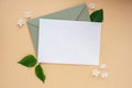 Composition with empty envelope and beautiful spring lilac flowers on beige background. Mockup card invitation greeting Royalty Free Stock Photo