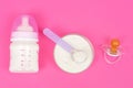 Composition with feeding bottle of baby milk formula on pink background Royalty Free Stock Photo