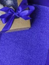 Composition of festive gift wrapped present box with blue satin bow on trendy blue background, copy space Royalty Free Stock Photo