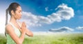 Composition of fit woman meditating over blue sky and clouds Royalty Free Stock Photo