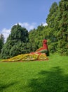 Composition of flowers in the form of a peacock in the park on the island of flowers Mainau, Constance, Germany. Vertical Royalty Free Stock Photo