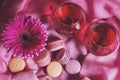 Composition of flowers, sweets and wine on a pink background