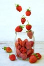 Composition of flying strawberry in jar. Cooking preparation compote or jam. Homemade conservation with organic fresh berry for th
