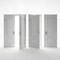 Four white wooden doors one slightly ajar revealing bright light isolated on white background Royalty Free Stock Photo