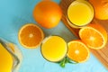 Composition with fresh orange juice in glassware, mint, and cutting board with oranges on color background, top view Royalty Free Stock Photo