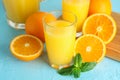 Composition with fresh orange juice in glassware, mint, and oranges on color background, closeup Royalty Free Stock Photo