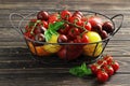 Composition of fresh ripe tomatoes of different varieties, spices, basil, rosemary, thyme, hot pepper in a basket on a wooden boar Royalty Free Stock Photo