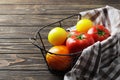 Composition of fresh ripe tomatoes of different varieties, spices, basil, rosemary, thyme, hot pepper in a basket on a wooden boar Royalty Free Stock Photo